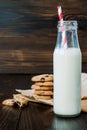 Stack of homemade chocolate chip cookies with milk on dark wooden table. Copy space background Royalty Free Stock Photo