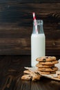 Stack of homemade chocolate chip cookies with milk on dark wooden table. Copy space background Royalty Free Stock Photo