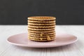 Stack of homemade Dutch stroopwafels with honey-caramel filling on a pink plate, side view