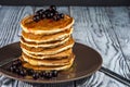 Stack of homemade pancakes with berries and honey on brown plate on rustic background. Royalty Free Stock Photo