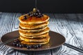 Stack of homemade pancakes with black currant and honey on brown plate on rustic background. Royalty Free Stock Photo