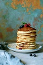 A stack of homemade  pancakes with fresh berry black currants and raspberries on a gray background. Royalty Free Stock Photo