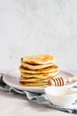 A stack homemade pancakes with honey. Light grey concrete background.