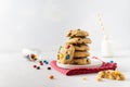 Stack of Homemade vanilla cookies decorated with multi-colored candy drops and a bottle of milk on white background. Side view, Royalty Free Stock Photo