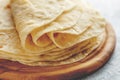 Stack of homemade wheat flour tortilla wraps on wooden cutting board.