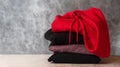 Stack of hooded sweatshirts and hoodie on gray background. Copy space