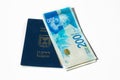 Stack of israeli money bills of 200 shekel and israeli passport Royalty Free Stock Photo