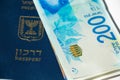 Stack of israeli money bills of 200 shekel and israeli passport Royalty Free Stock Photo