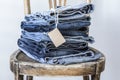 Stack of jeans with tag on wooden chair