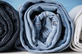 Stack of jeans of various shades, close-up. Jeans are stacked on a wooden background Royalty Free Stock Photo