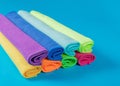 Stack of kitchen microfiber towels in bright colors on a blue background