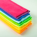 Stack of kitchen microfiber towels in bright colors on a light mirror background