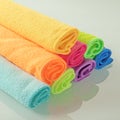 Stack of kitchen microfiber towels in bright colors on a light mirror background