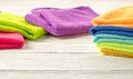 Stack of kitchen microfiber towels in bright colors on a white wooden background