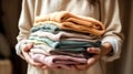Stack of knitted clothes in female hands, generative AI. Royalty Free Stock Photo