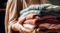 Stack of knitted clothes in female hands, generative AI. Royalty Free Stock Photo
