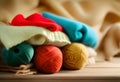 Stack of knitted clothes on wooden table opposite a defocused burlap background. Toned