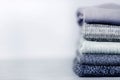 A stack of knitted jumpers and sweaters on a gray concrete blurry background. Royalty Free Stock Photo