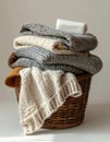Stack of Knitted Sweaters in Brown Wicker Basket Royalty Free Stock Photo