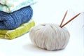 Stack of knitted sweaters and knitting needles with a ball of yarn. Home comfort. Casual wear