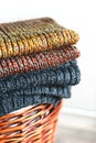 Stack of knitted winter scarfs on straw basket. Royalty Free Stock Photo