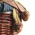 Stack of knitted winter scarfs on straw basket. Royalty Free Stock Photo