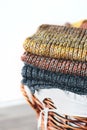 Stack of knitted winter scarfs on straw basket. Royalty Free Stock Photo