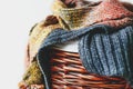 Stack of knitted winter scarfs on straw basket. Royalty Free Stock Photo