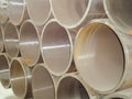 Stack of large diameter steel pipes in an industrial warehouse. Manufacture of building constructions and engineering networks. Royalty Free Stock Photo