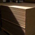 Stack of large, flat, brown corrugated cardboard sheets, neatly piled on a wooden Royalty Free Stock Photo