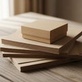 A stack of light brown textured cardboard sheets lies on a wooden surface Royalty Free Stock Photo