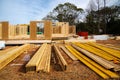 Stack of lumbers in front of timber frame house with post, beam, OSB (Oriented Strand Board) plywood sheathing