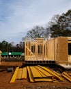 Stack of lumbers in front of timber frame house with post, beam, OSB (Oriented Strand Board