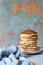 A stack of lush punkcakes for breakfast on a gray background. High pile of delicious pancakes with berries.