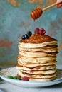 A stack of lush punkcakes for breakfast on a gray background. High pile of delicious pancakes with berries.