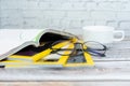 Stack magazines with glasses on wooden table. Royalty Free Stock Photo