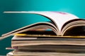 Stack of magazines on a table with colorful backdrop in a well-lit room Royalty Free Stock Photo