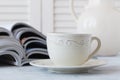 Stack of magazines and white cup of coffee on white background. Royalty Free Stock Photo