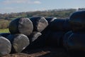 Stack of many hay bales wrapped in black on a sunny day. Use of plastic Royalty Free Stock Photo