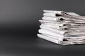 Stack of many newspapers on grey background, space for text Royalty Free Stock Photo