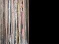 Stack of many vinyl records in old color covers on left side on photo on black background Royalty Free Stock Photo