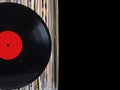 Stack of many vinyl records in old color covers on left side on photo on black background Royalty Free Stock Photo