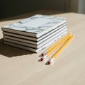 Stack of Marble Notebooks and Pencils on Wooden Desk Royalty Free Stock Photo