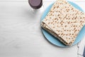 Stack of matzos and red wine on white wooden table, flat lay. Space for text Royalty Free Stock Photo