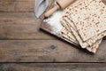 Stack of matzos and rolling pin on wooden table, flat lay. Space for text Royalty Free Stock Photo