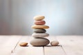 stack of meditation stones on a light wooden table