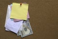 A stack of memo notes with payment receipt and dollar bill on notice cork board. Copy space for text, logo Royalty Free Stock Photo