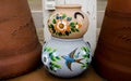 Stack of Mexican ceramic decorative pots between large terracotta pots
