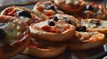 Stack of mini pizzas with one black olive on the top of each one