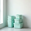 Stack of mint green plastic storage containers placed against a white wall. Boxes are different sizes. Everyday home organization Royalty Free Stock Photo